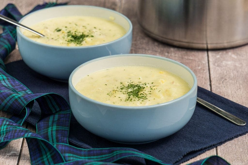 Cullen Skink Recipe - Traditional Scottish Smoked Fish Soup - Two bowls of smoked haddock chowder with pot in the background
