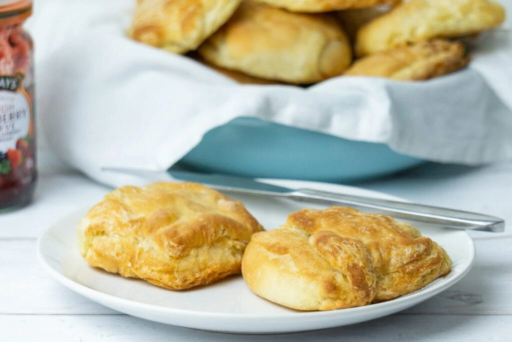 Butteries recipe - Butteries on a plate with jar of jam and bowl of butteries in the background
