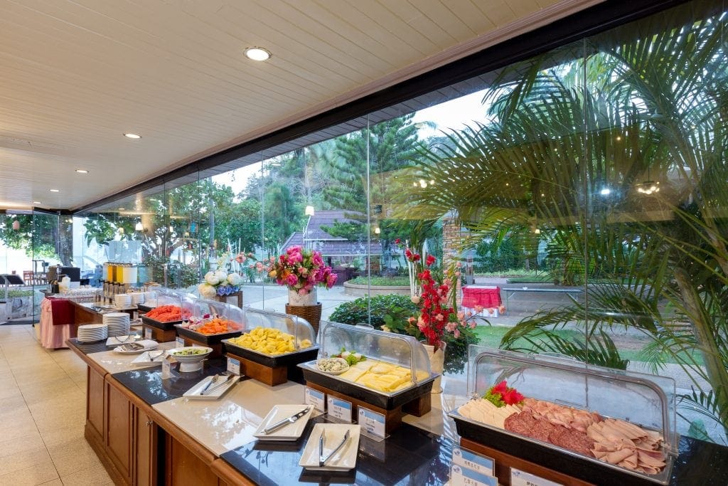 six displays of food are lined near a floor to ceiling glass window.
