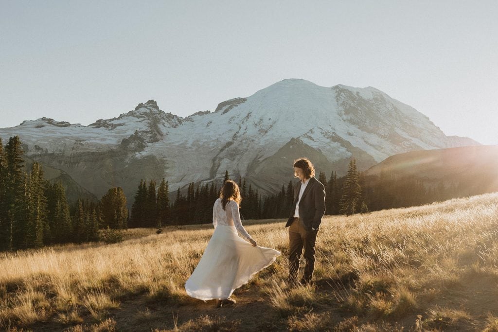 A newlywed couple stand in the mountain fields during their Mount Rainier Cabin Elopement photographed by Alexa Ann Photography, a Seattle Elopement Photographer.