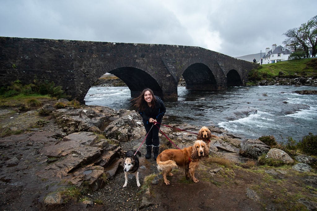 Brooke with the 3 dogs we were watching next to a river by a bridge outside of the Isle of Skye