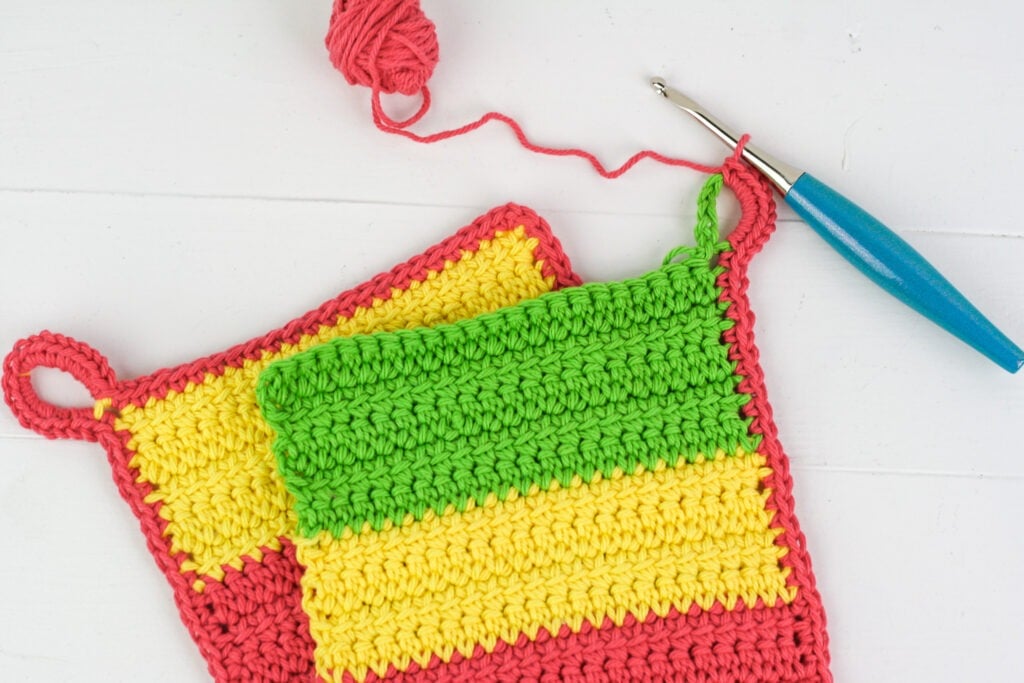Make a quick, easy and modern crochet potholder with hanging loop. Video tutorials to help guide you through the pattern. Great for using up scrap cotton.