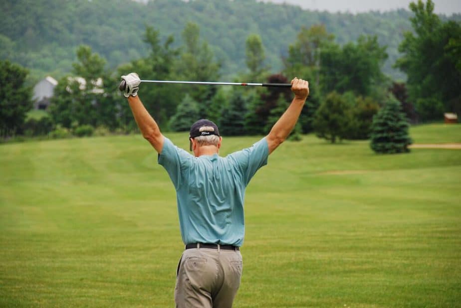 A golfer is stretching his shoulders