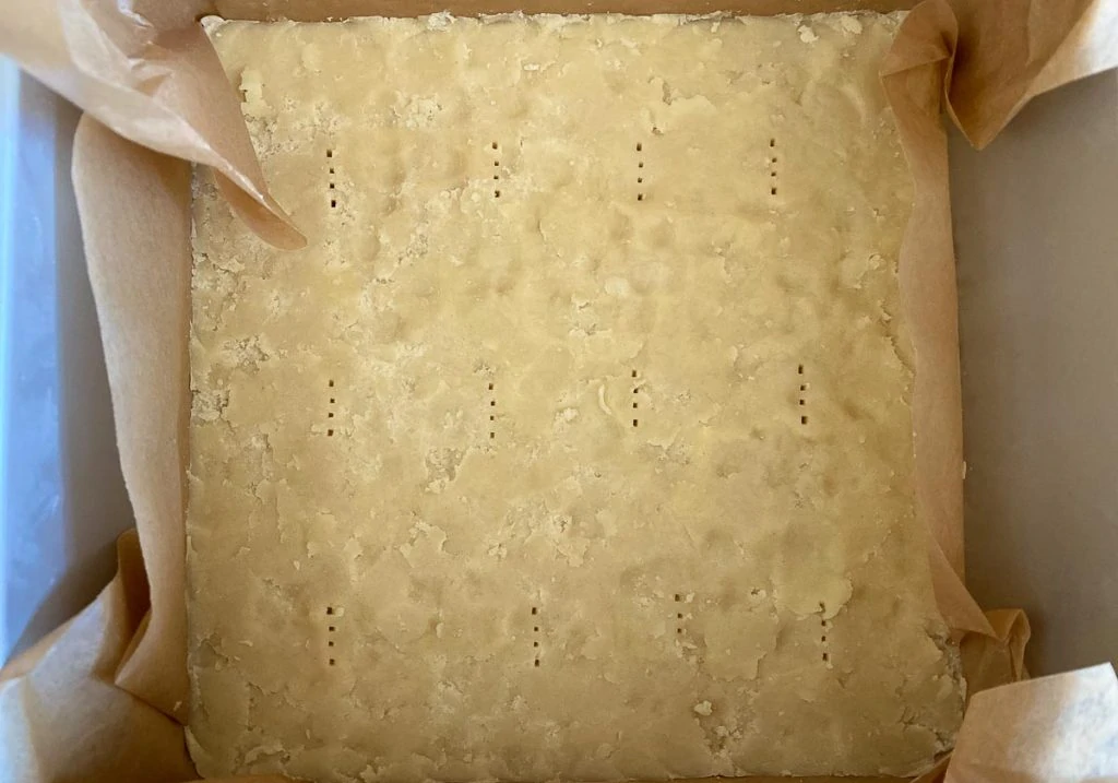 Caramel Slice Recipe - Shortbread in tin pricked with fork and ready to bake