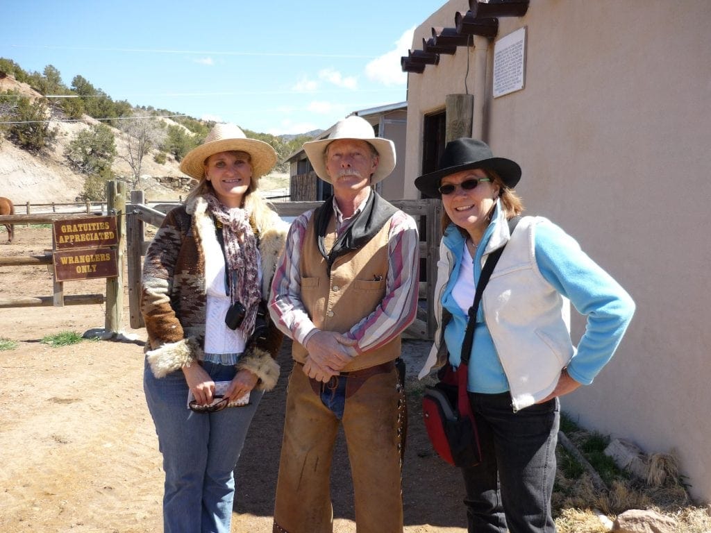 two women travel writers in cowboy hats stand next to Santa Fe cowboy trail guide