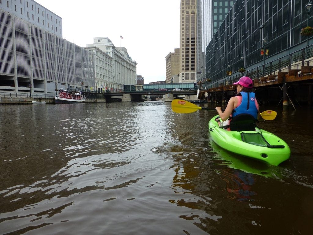 Kayaker looks at Milwaukee skyscrapers while urban kayaking