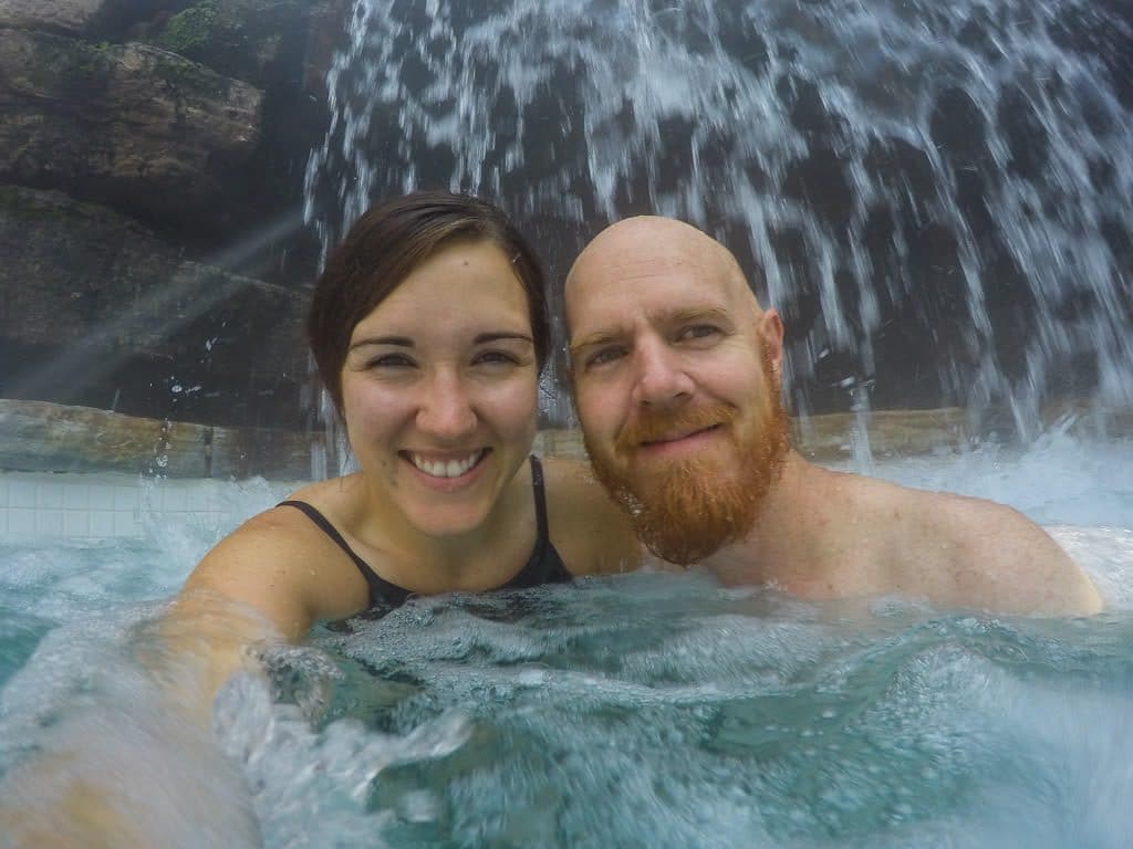 Brooke and Buddy taking a selfie under a waterfall at scandinave spa in mont-tremblant