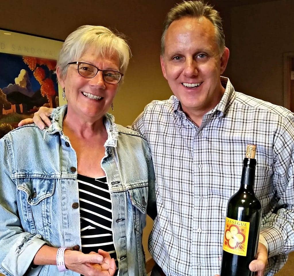 Stacey Wittig stands with Irby Woods, who is holding wine bottle