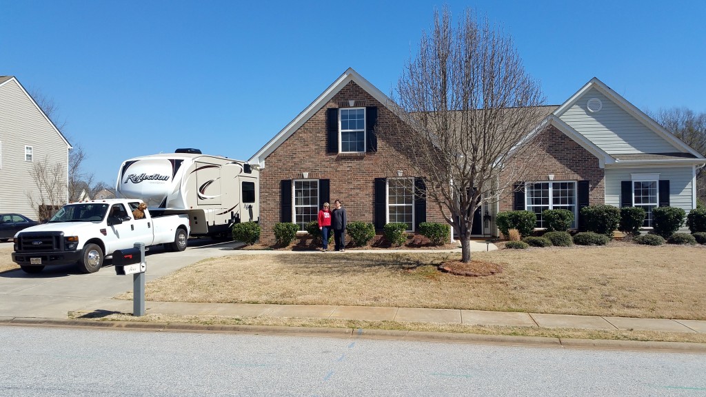 This is Elijah and I standing in front of our old house. I like this picture because we have our new right next to our old. "Bye, House"