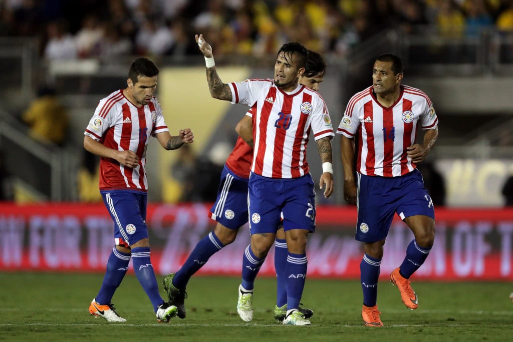 PASADENA, CA - JUNE 07: Victor Ayala #20 waves to the audience after scoring a goal as Paulo da Silva #14, and Celso Ortiz #16 of Paraguay congratulate him to the during the second half of a 2016 Copa America Centenario Group A match between Columbia and Paraguay at Rose Bowl on June 7, 2016 in Pasadena, California. (Photo by Sean M. Haffey/Getty Images)