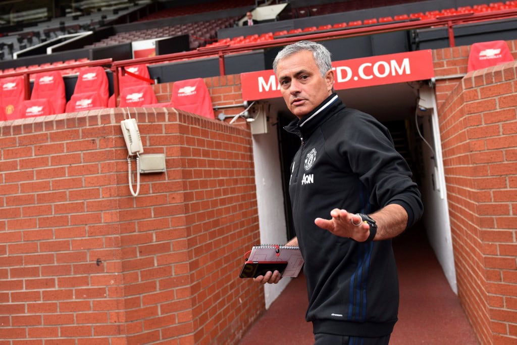 Manchester United's new Portuguese manager Jose Mourinho arrives to pose with a football shirt during a photocall on the pitch at Old Trafford stadium in Manchester, northern England, on July 5, 2016. Jose Mourinho officially started work as Manchester United manager at the club's Carrington training base yesterday. The 53-year-old was appointed as United boss in May after the sacking of Dutchman Louis van Gaal. (Photo credit: Oli Scarff/AFP/Getty Images)