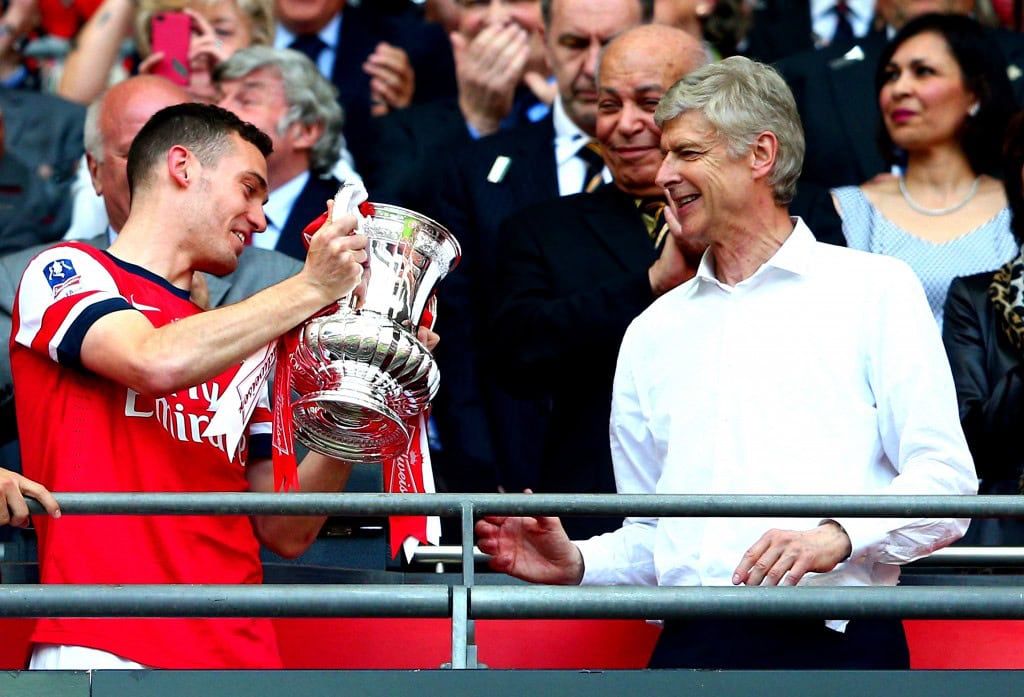 LONDON, ENGLAND - MAY 17: Captain Thomas Vermaelen of Arsenal passes the trophy to Arsene Wenger manager of Arsenal (R) after the FA Cup with Budweiser Final match between Arsenal and Hull City at Wembley Stadium on May 17, 2014 in London, England. (Photo by Clive Mason/Getty Images)