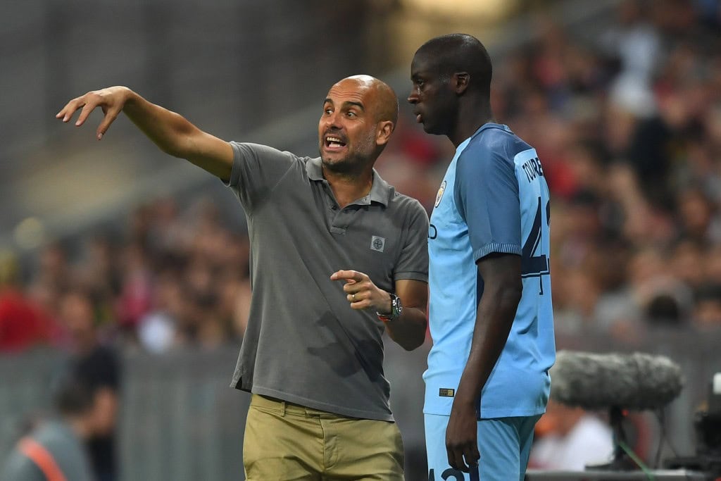 MUNICH, GERMANY - JULY 20: Pep Guardiola the manager of Manchester City speaks with substitute Yaya Toure of Manchester City during the pre season friendly match between Bayern Muenchen and Manchester City F.C at the Allianz Arena on July 20, 2016 in Munich, Germany. (Photo by Lennart Preiss/Bongarts/Getty Images)