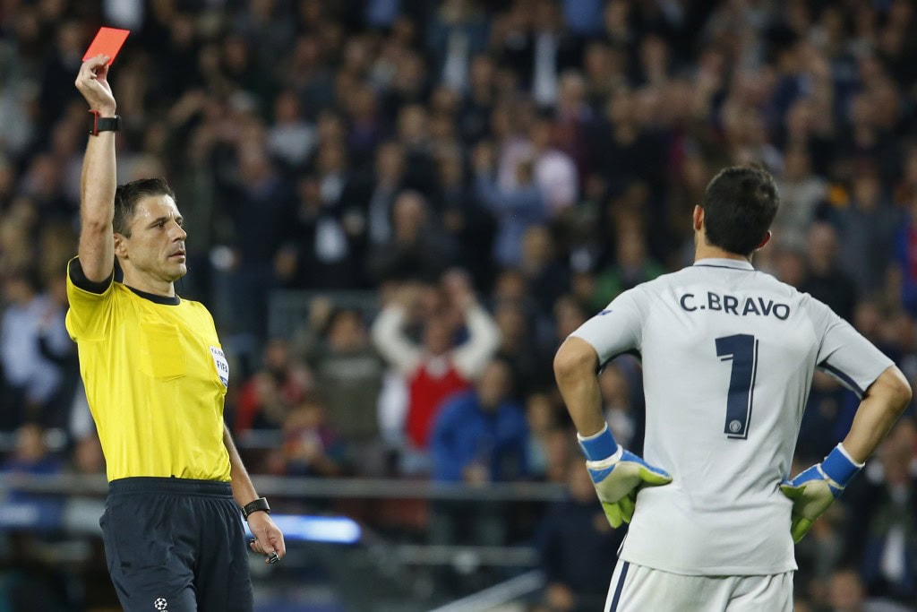 TOPSHOT - Referee shows a red card to Manchester City's Chilean goalkeeper Claudio Bravo (R) during the UEFA Champions League football match FC Barcelona vs Manchester City at the Camp Nou stadium in Barcelona on October 19, 2016. / AFP / PAU BARRENA (Photo credit should read PAU BARRENA/AFP/Getty Images)