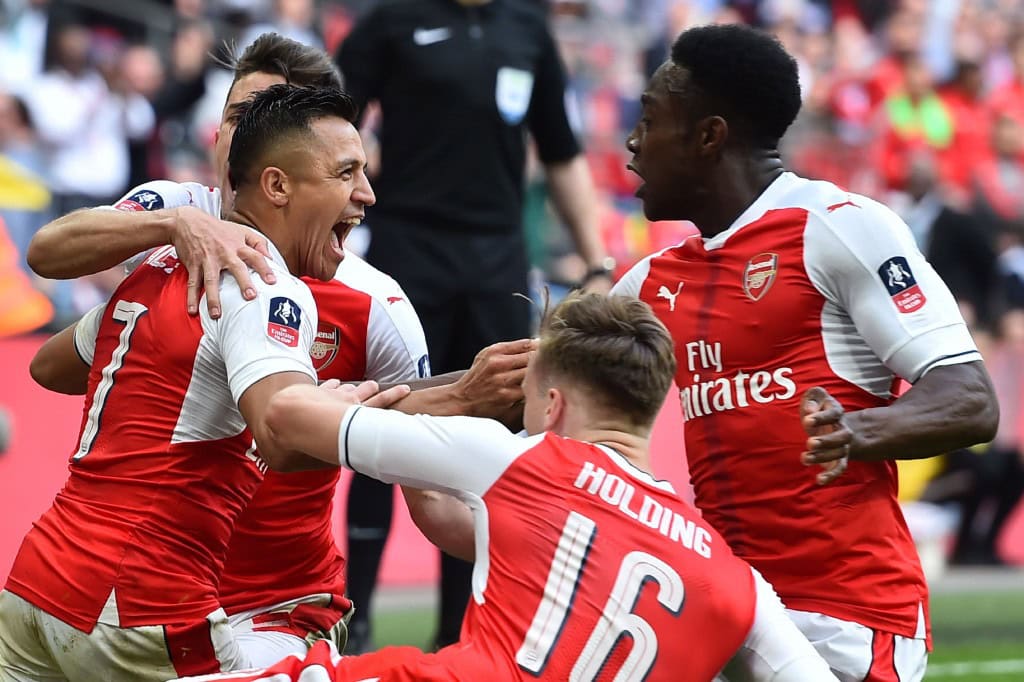 Arsenal's Chilean striker Alexis Sanchez (L) celebrates scoring the second goal with teammates during the FA Cup semi-final football match between Arsenal and Manchester City at Wembley stadium in London on April 23, 2017. / AFP PHOTO / Glyn KIRK / NOT FOR MARKETING OR ADVERTISING USE / RESTRICTED TO EDITORIAL USE (Photo credit should read GLYN KIRK/AFP/Getty Images)