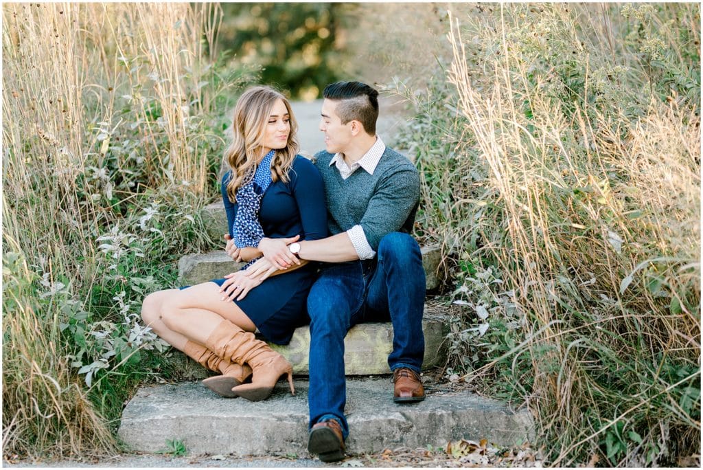 engaged couple sitting on the stairs looking at each other during an engagement session in Chicago Lincoln Park zoo photographer by Bozena Voytko Photography