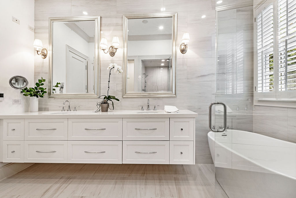 bathroom with double vanity top with white drawers golden mirrors, and light fixtures by Chicago interior photographer bozena voytko