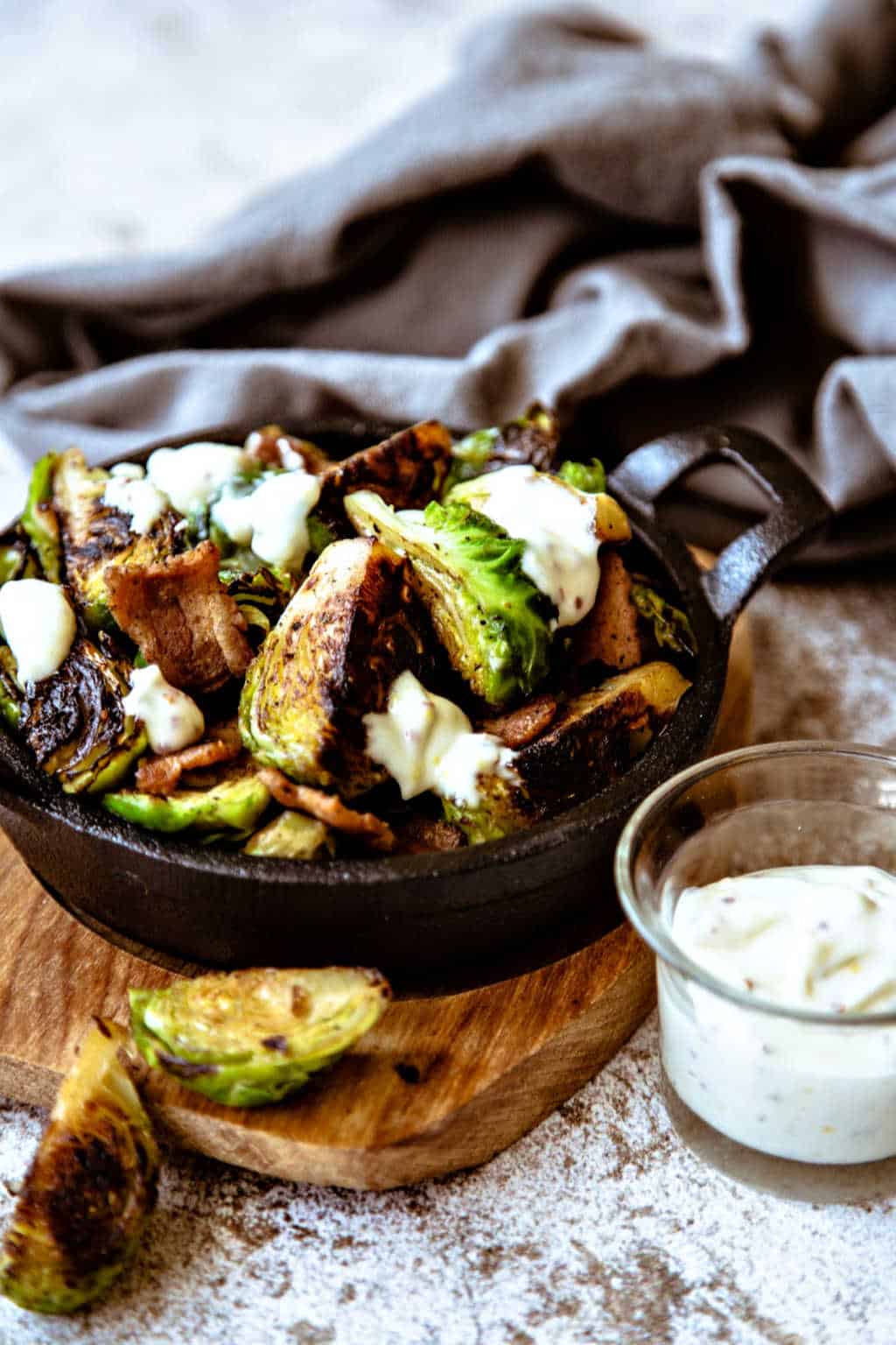 appetizer of charred brussel sprouts with a side of garlic aioli