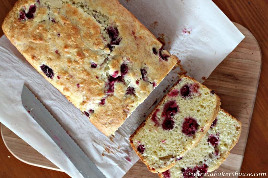 Overhead view of raspberry bread on a cutting board with parchment