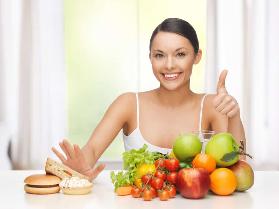 A girl is choosing vegetables instead meat and cake