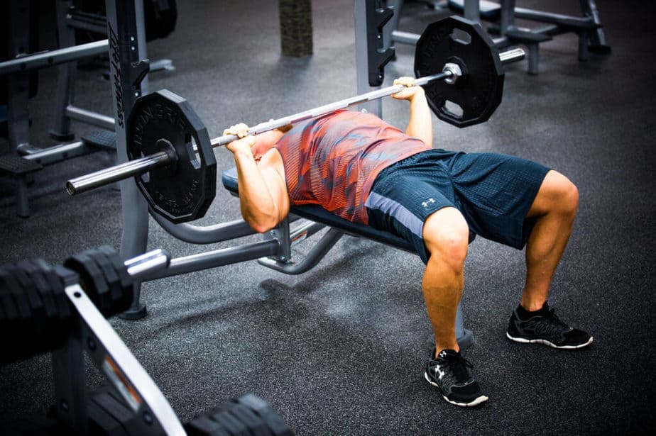 A guy has a training with weights at the gym