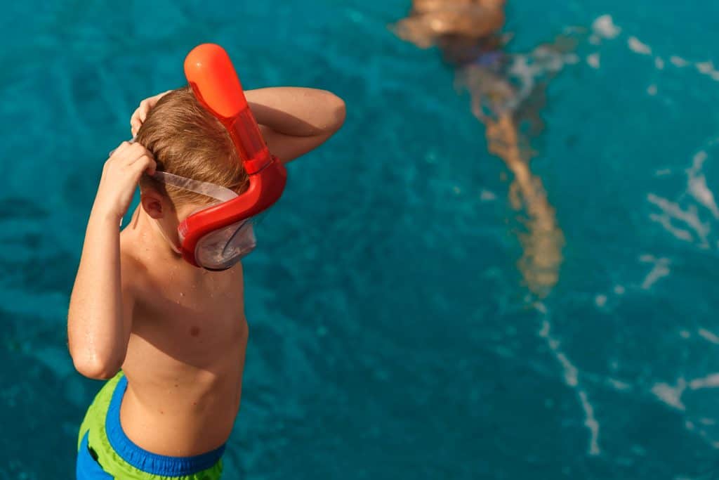 Child Putting on a full face snorkel goggles