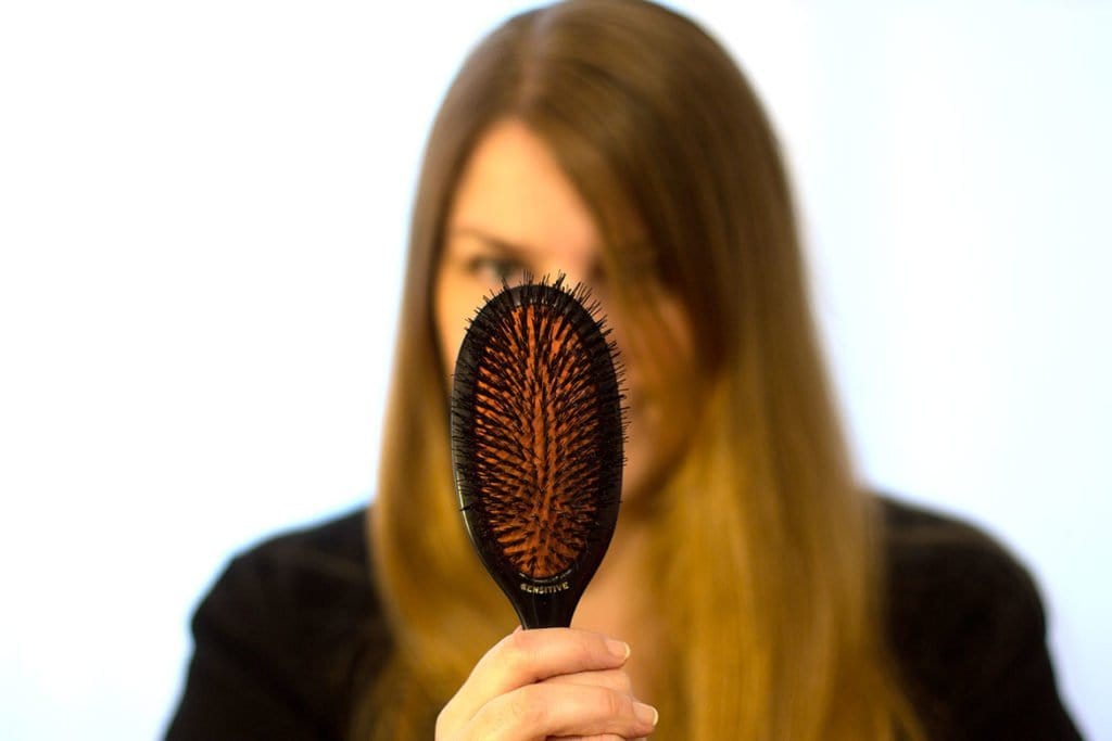Femme qui tient brosse à cheveux Mason Pearson
