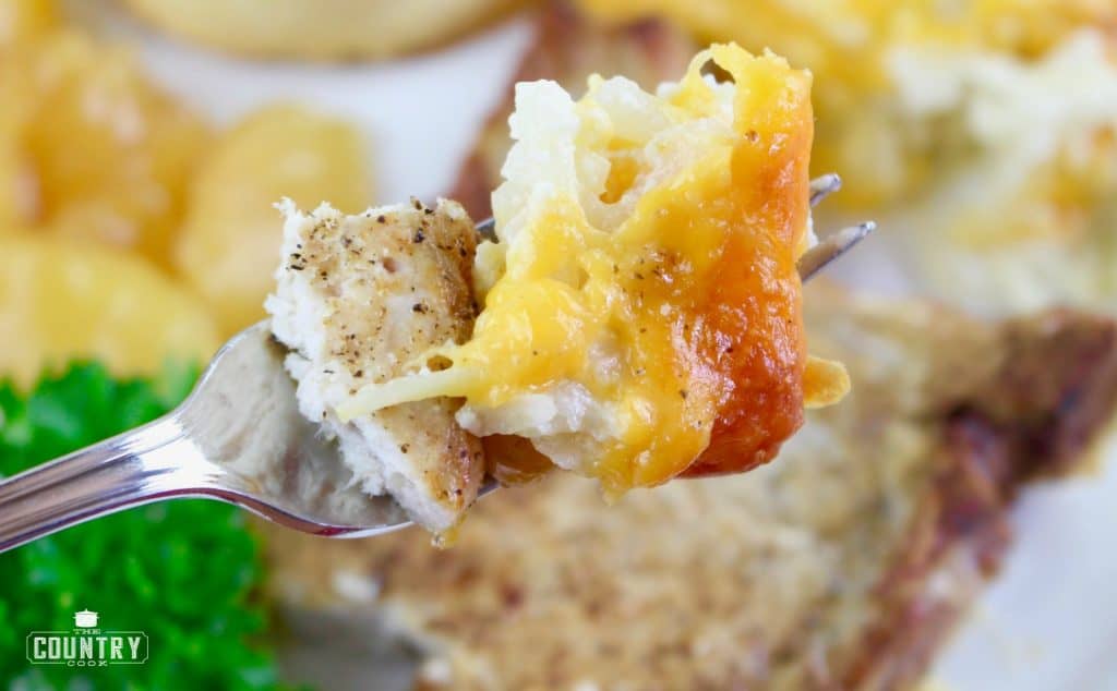 pork chop with hash brown casserole on fork