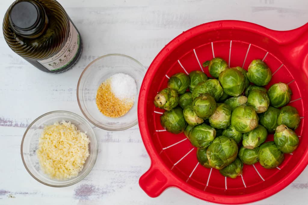 ingredients for smashed brussels sprouts: sprouts, oil, parmesan, garlic powder, and salt