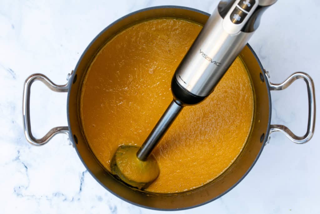 pureeing soup with immersion blender in large pot
