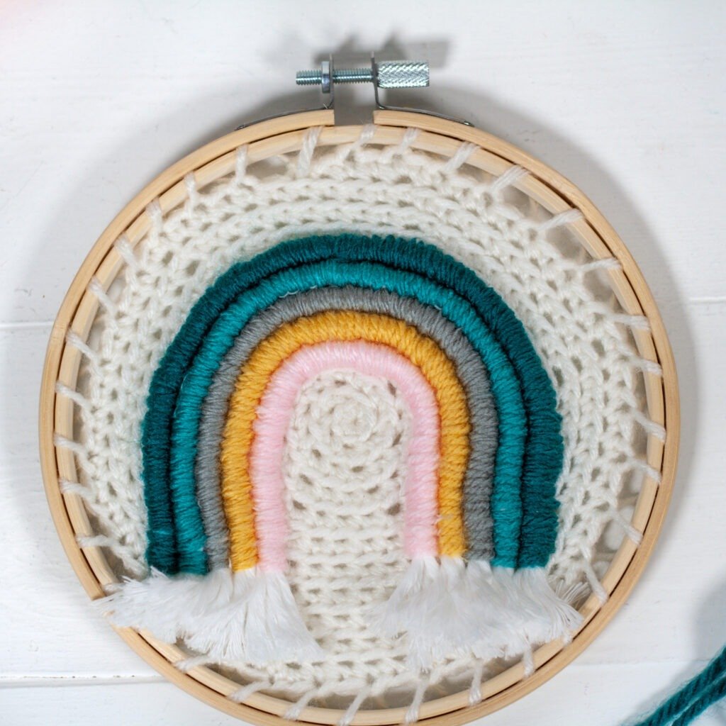 Learn how to make embroidery crochet rainbow wall hanging. You will be using your crochet skills and learning to embroider with a video.