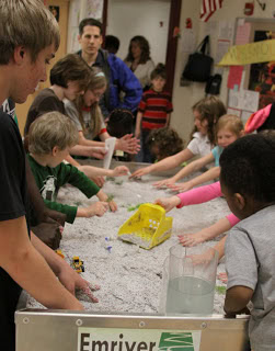 River models and young students; redesign continues.
