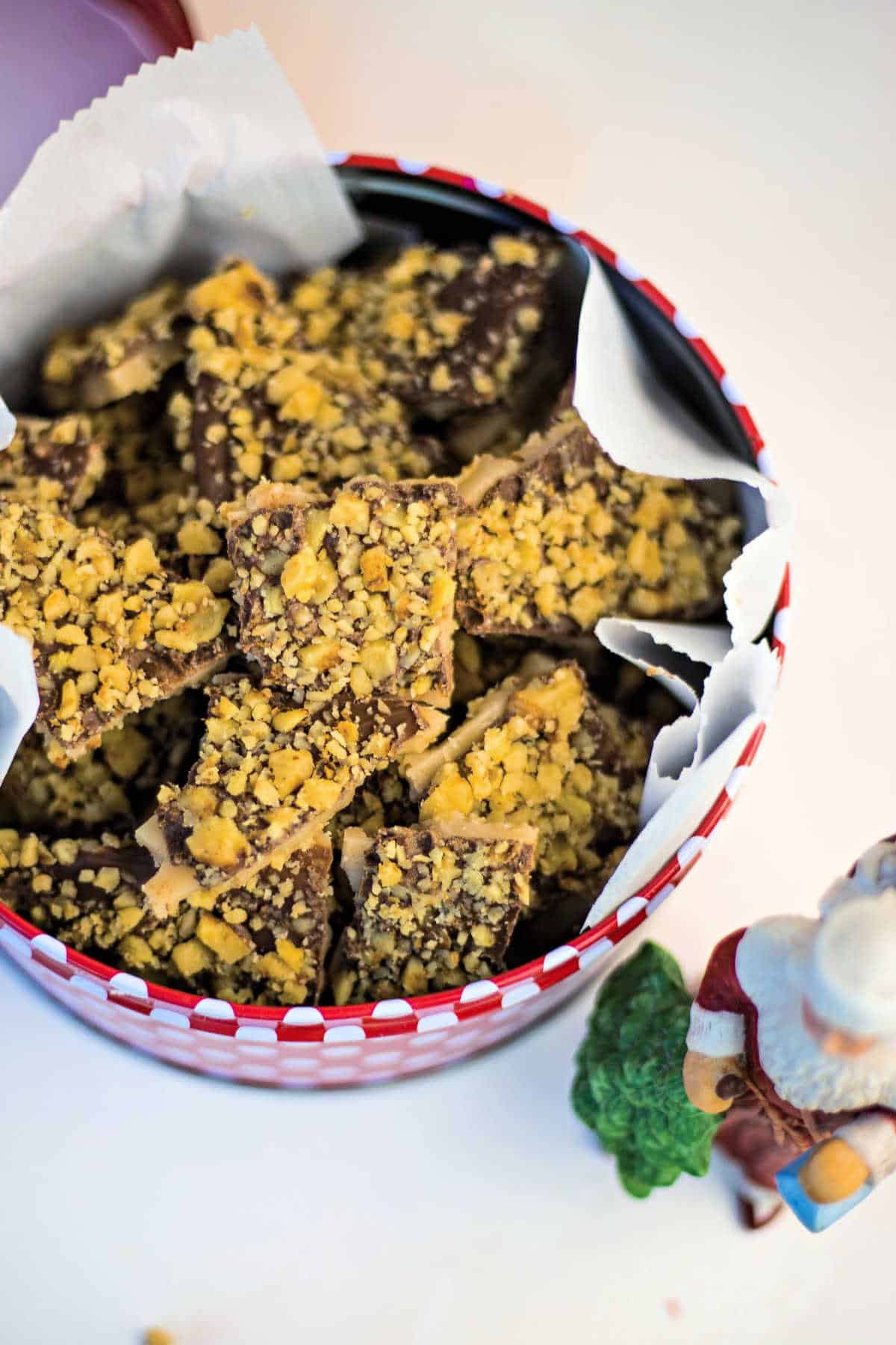red and white polka dot tin filled with English toffee and a Santa figurine