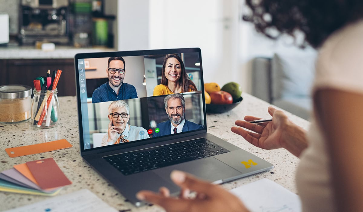 Woman video-chatting with four people on a computer