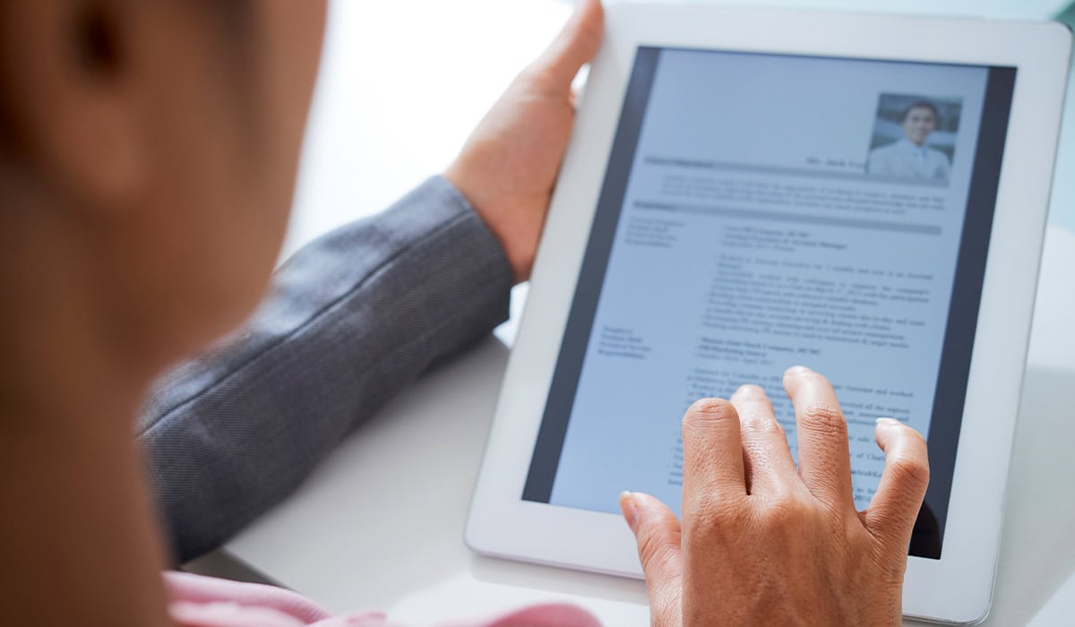 Man looking at a resume on a tablet