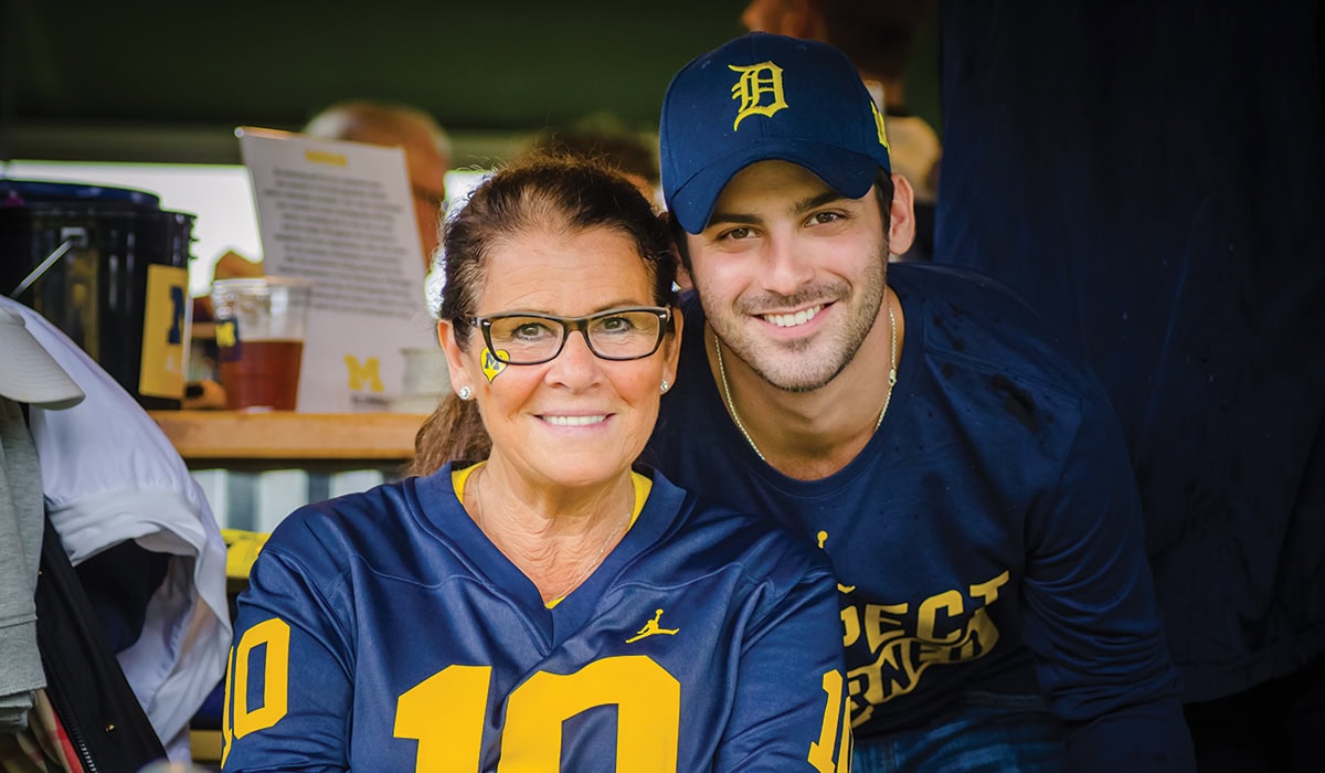 Two people wearing Michigan gear pose for a picture