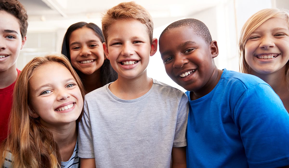 Portrait Of Smiling Male And Female Students In Grade School Classroom