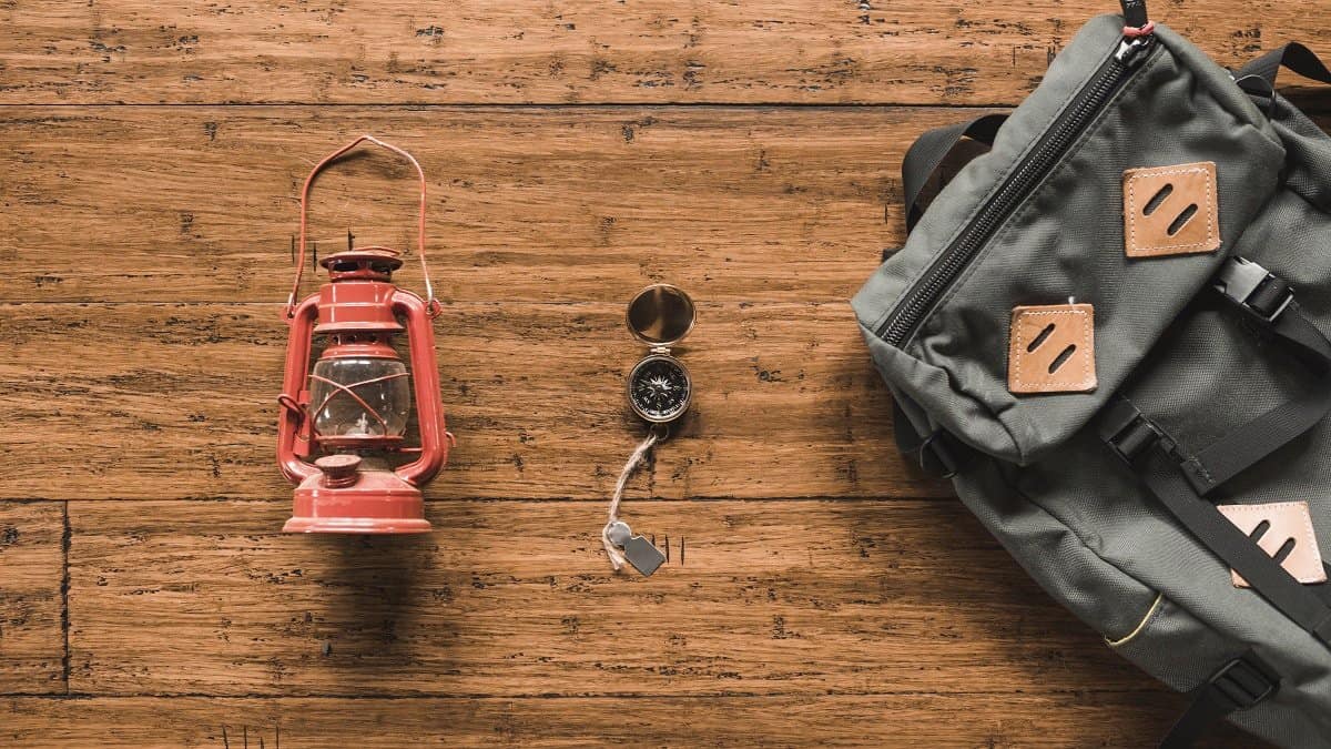 backpack and lantern on the wooden background