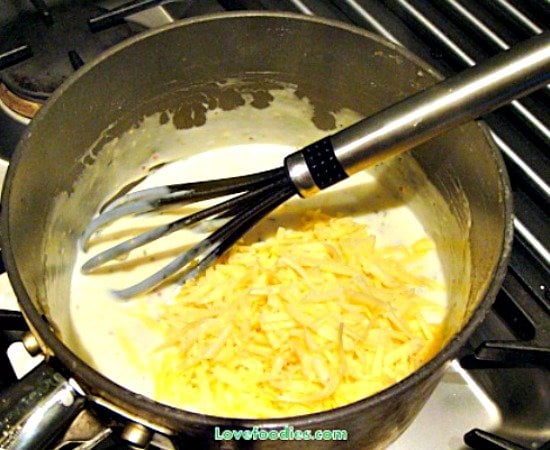How To Make A Basic Cheese Sauce with NO lumps, showing grated cheese added
