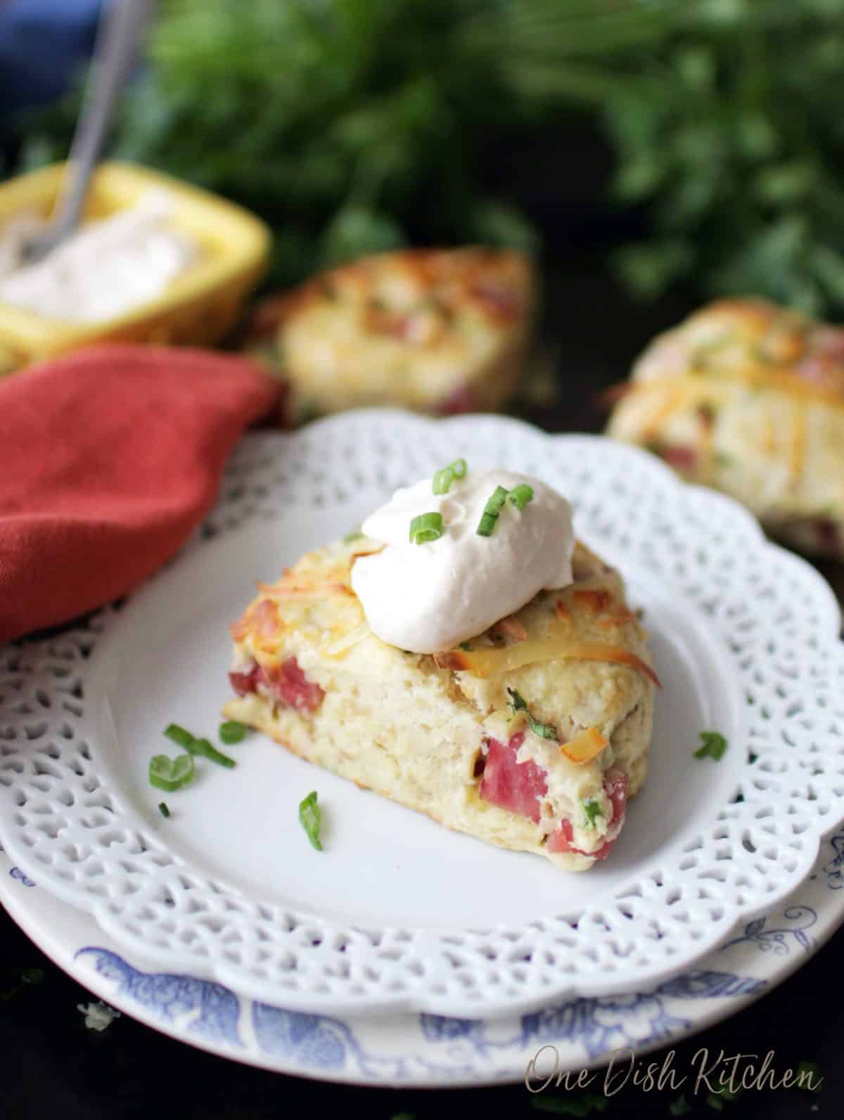 one ham scone on a white plate next to two scones.