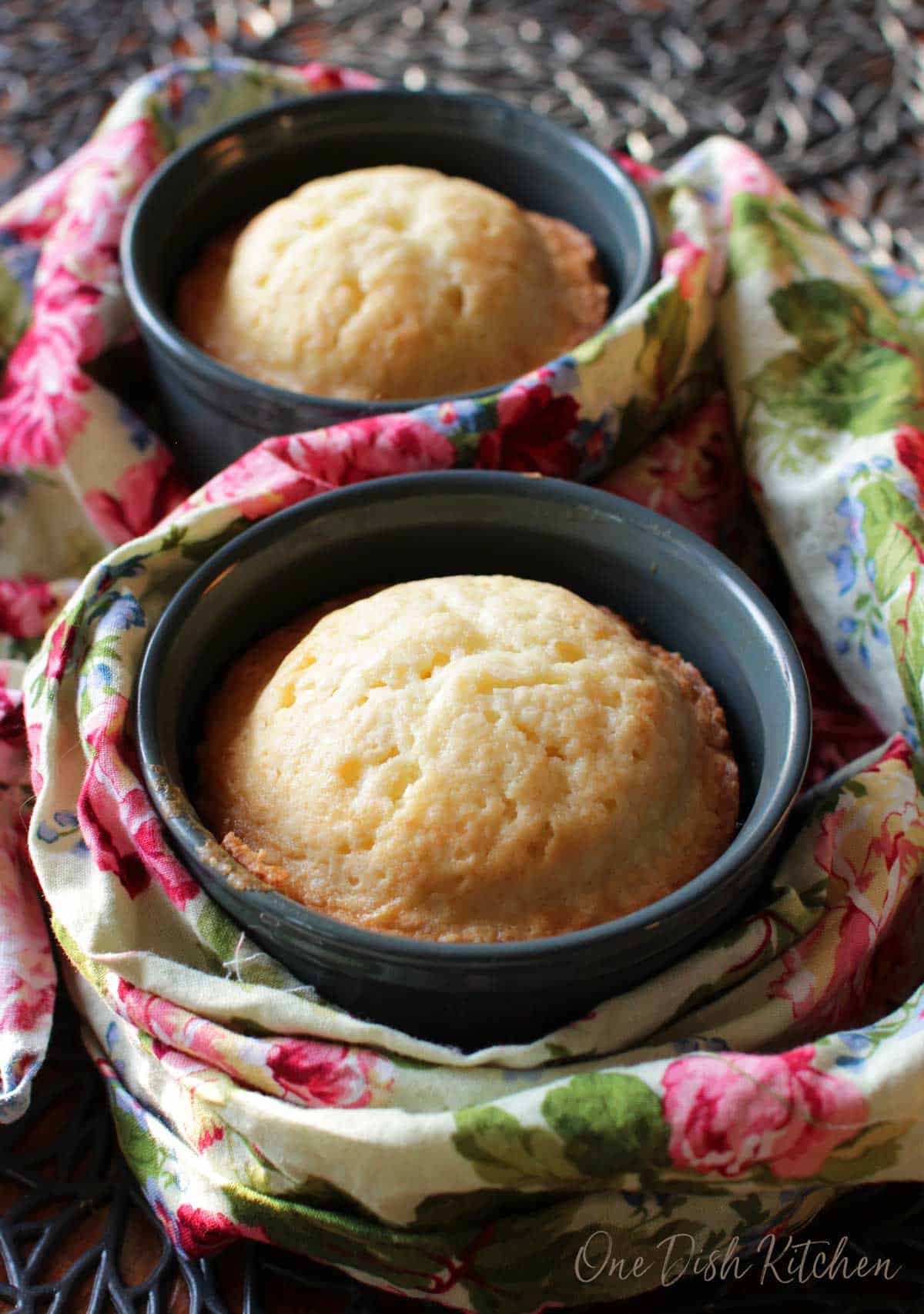Two green ramekins filled with pound cake on a flowered napkin.