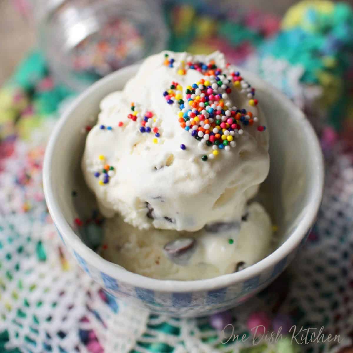 a close up of a small bowl of mint ice cream topped with colored sprinkles.
