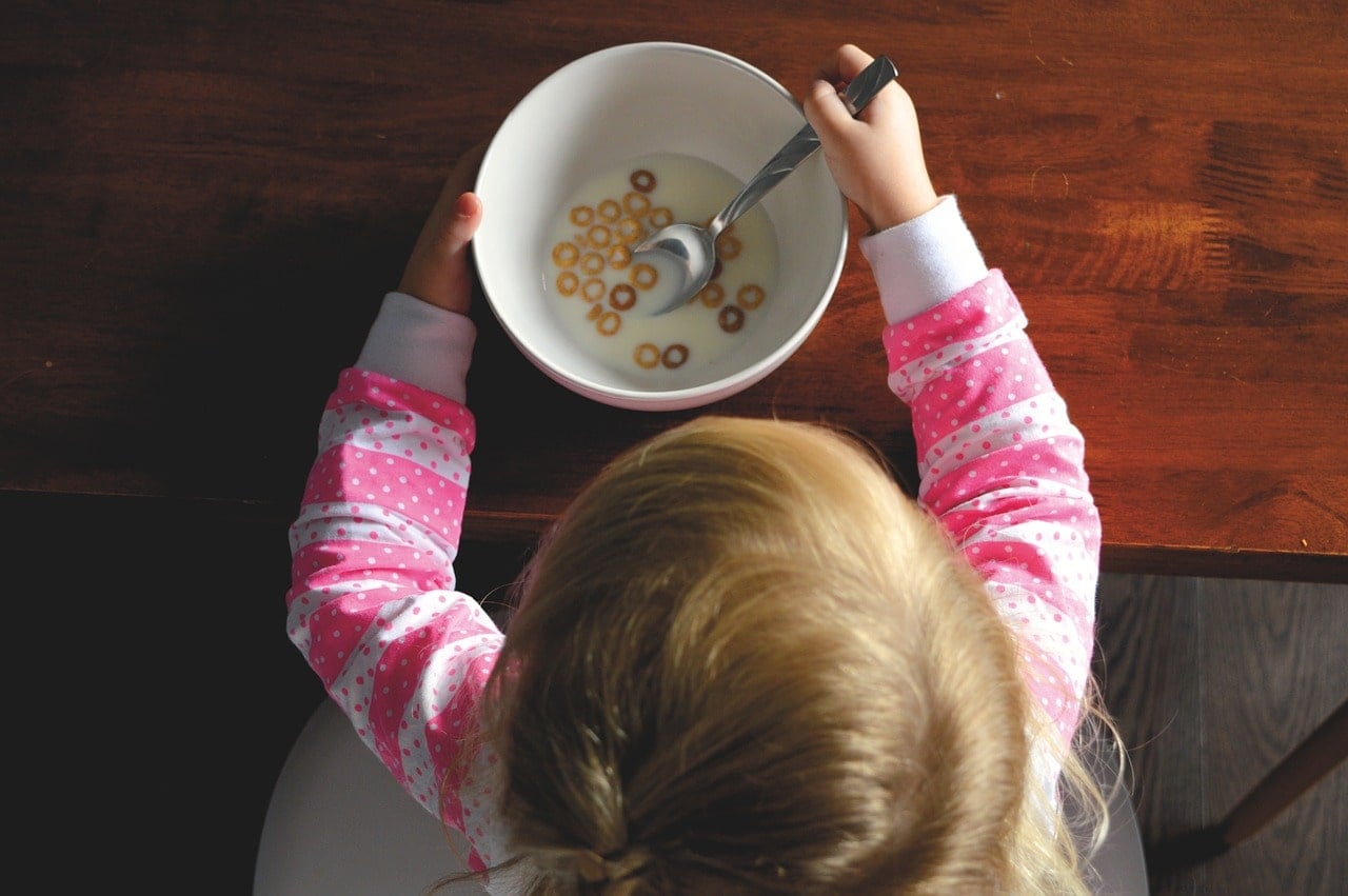 intolleranza al lattosio: bambina che mangia latte e cereali