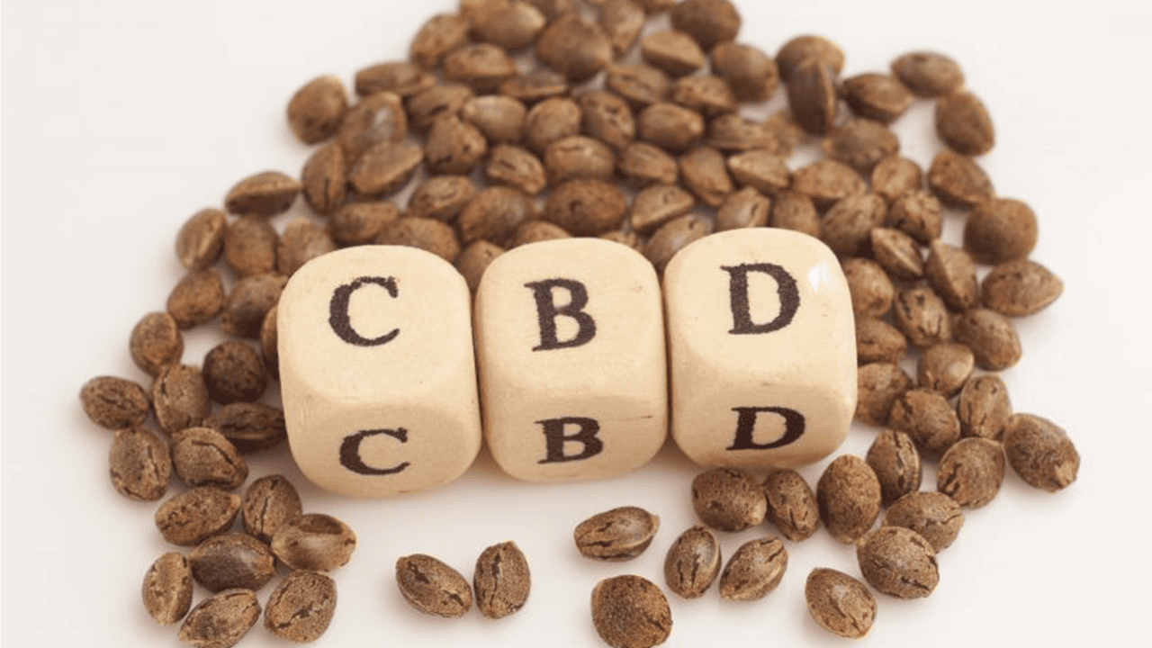 Letter blocks reading CBD in small pile of hemp seed