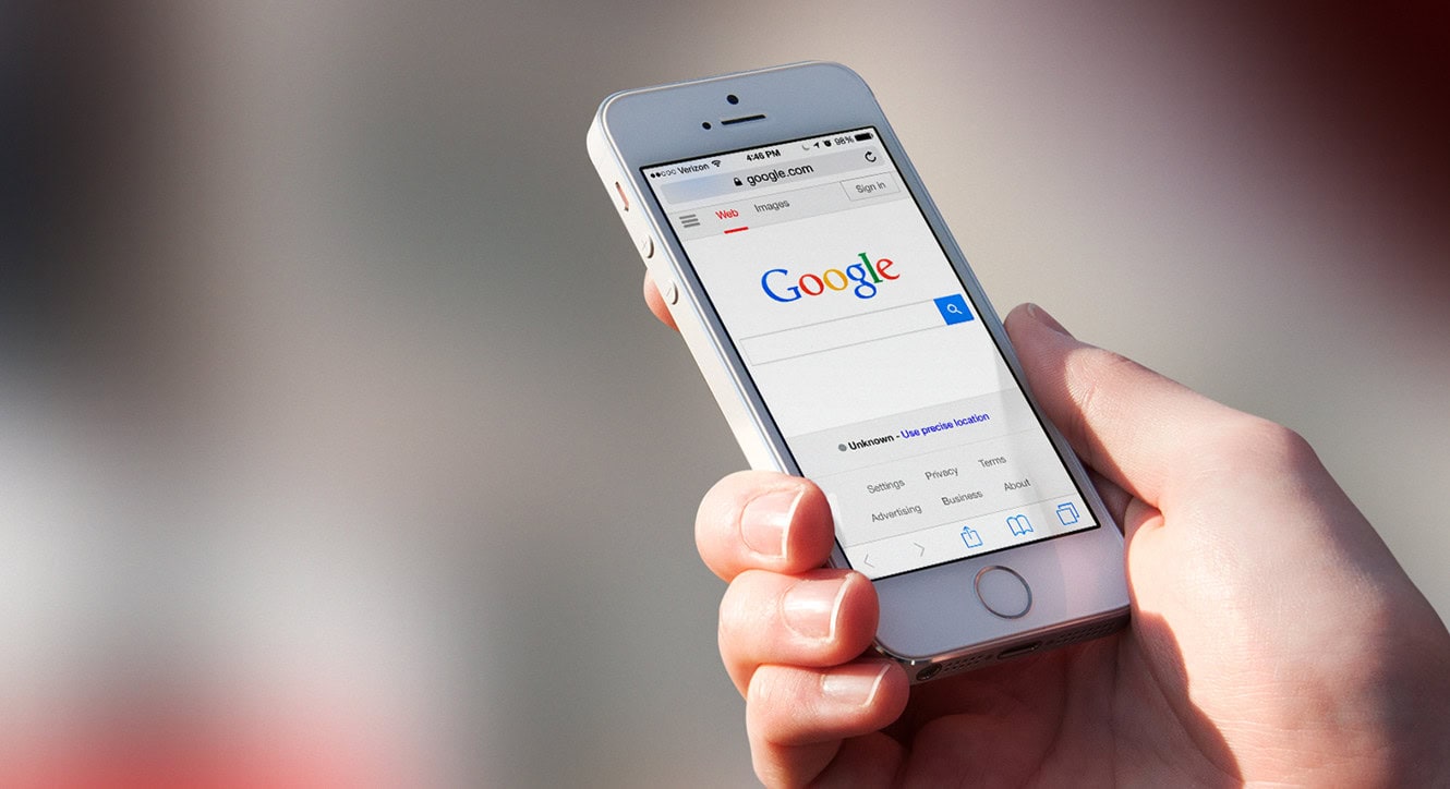 Hand holding a smartphone with Google opened