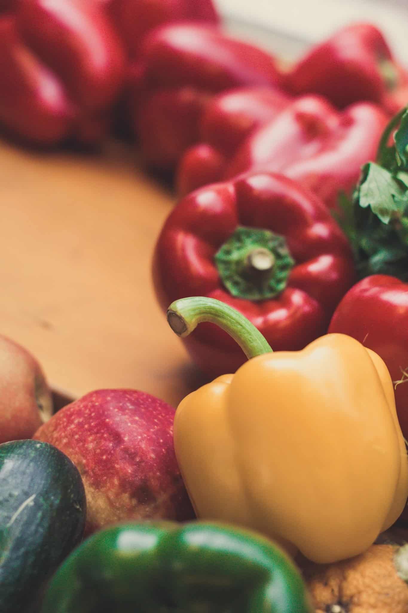 Different colored bell peppers on a cutting board.