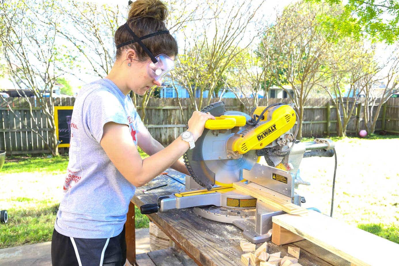 Woman outside using a miter saw on a table