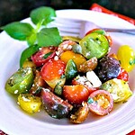 Garden fresh tomatoes make all the difference in the world when it comes to Summer salads, and now that they are in season, it’s the perfect time to enjoy this simple Greek Heirloom Tomato Salad. Dressed simply with a good quality extra-virgin olive oil, toss together a mixture of red, yellow, and green cherry tomatoes (or use heirloom tomatoes) with fresh herbs, capers, and Feta cheese and you have a tasty and gorgeous dish in just five minutes! #heirloomtomato #salad #recipe