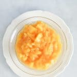 A plate of peach compote on a marble surface