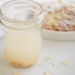Almond extract in a glass jar on a white background
